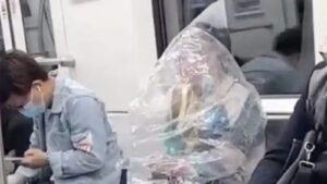 China: Woman eats banana on train covered in plastic bag .